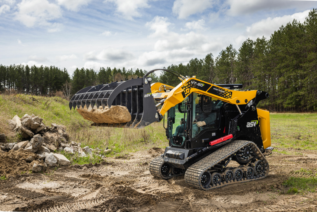 An ASV VT-80 lifts a rock with a grapple rake